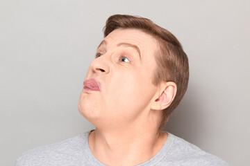 Portrait of disgruntled mature man showing tongue and teasing