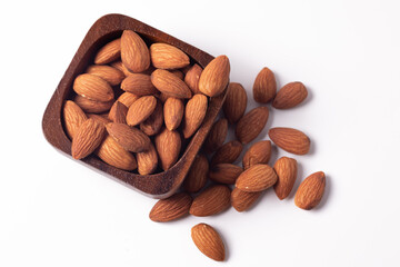 Almonds in a wooden cup on a white background