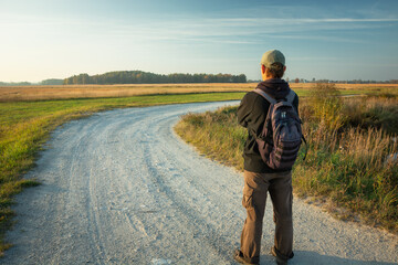 Man standing in front of a bend on a dirt road