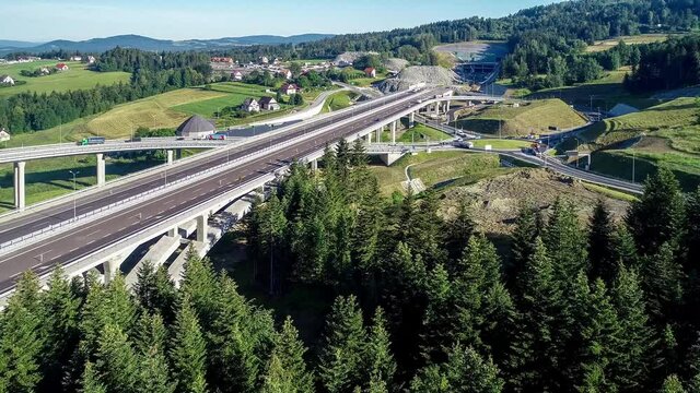 New highway and tunnel under construction in Poland on national road no 7, E77, called Zakopianka, in July 2020. Traffic circle and slip roads. Aerial video