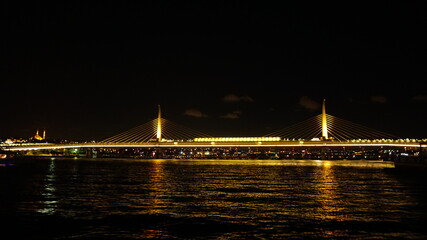 Golden Horn Metro Bridge in Istanbul at night, black sky and sea, Gold color reflection, background