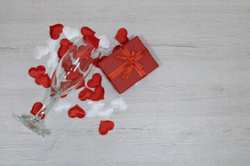 A crystal glass poured red hearts into a red gift box.