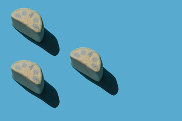 Pattern of tasty marshmallows with hard shadows on a blue background.