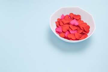 ブルーの背景に置いた白い皿とハート型のスポンジ