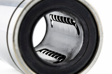 Macro shot of the inside of a linear bearing, isolated on a white background, selective focus.