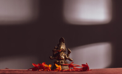 Ganesha / Ganapathi idol decorated with flowers and interesting background for Ganesh Chaturthi