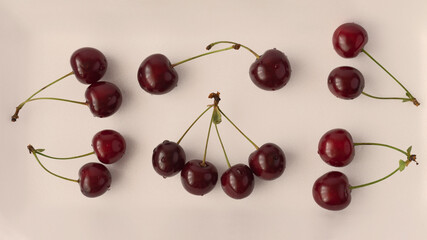 Naklejka na ściany i meble Many ripe cherries are on the table. Cherries with green tails. Vanilla toning