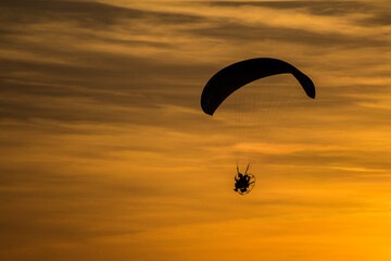 sunset with aragliding in the sky