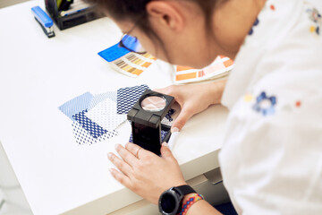Female fashion designer holding color samples choosing fabric textile at workplace, dressmaker or tailor checking fabric quality, close up view   