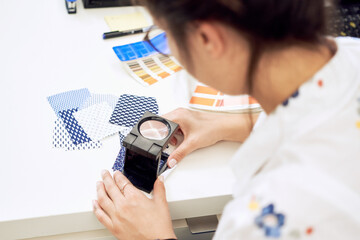 Female fashion designer holding color samples choosing fabric textile at workplace, dressmaker or...