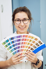 Color scale, decoration, design and people concept - smiling young woman with color swatches or...