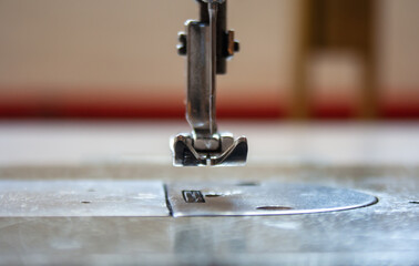sewing machine foot and needle. Close up, macro. Empty space for text. Craft fabric industrial.