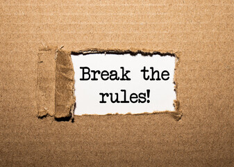 The text BREAK THE RULES behind torn brown paper