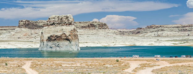 Scenic view of Lone Rock Beach with camping vehicles at Lake Powell in the desert in the United...