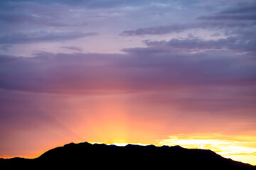 Sunrise dawn twilight with dark silhouette of mountains and pastel sunlight on Great Salt Lake in Antelope Island State Park from Ladyfinger campground in Utah