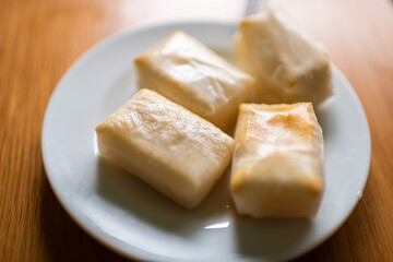 Cooked white mochi rice cakes roasted toasted baked in oven in traditional Japanese way on plate macro closeup of texture