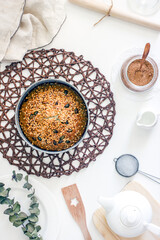 Delicious homemade pie with poppy seeds and nuts on a white table surrounded by dishes and kitchen utensils,poppy seed cake. Top view, flat lay, Top-down food