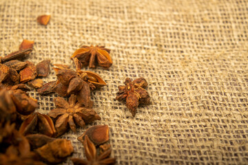 A pile of star anise on a background of burlap with a rough texture surface texture. Close up.