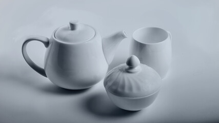 white porcelain tea-ware set - teapot, sugar bowl, cup, on a white background