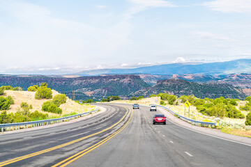 Naklejka premium Hrabstwo Santa Fe na pustyni w Nowym Meksyku z samochodami jadącymi autostradą do Los Alamos jadącymi ulicą 502 na zachód