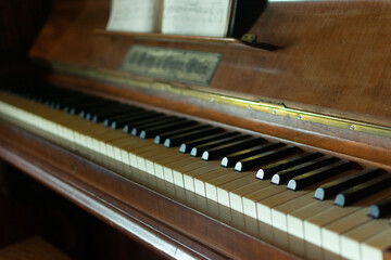 Fototapeta na wymiar Closeup of black and white piano keys and wood grain with sepia tone