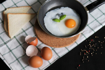 Culinary background with fried eggs in a pan, eggs, peas pepper on a white checkered tablecloth. Culinary concept. the process of cooking eggs. Illustration for cookbook.