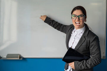 Angry business woman coach points finger to white board in office.A disgruntled female boss is...