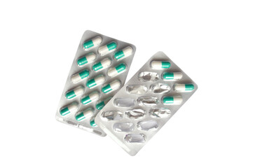 Pills capsules in the package isolated on white background. White and green tablets. Concept of health and medicine. Full and empty packaging.