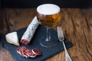 preparacion de embutidos sobre plato de piedra y fondo de madera 