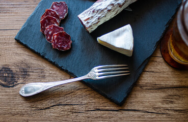 preparacion de embutidos sobre plato de piedra y fondo de madera 