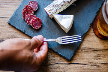 preparacion de embutidos sobre plato de piedra y fondo de madera 