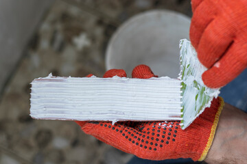 Applying white glue on a decorative facing tile.