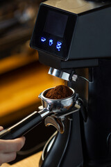 coffee grinder grinding coffee pouring into a portafilter