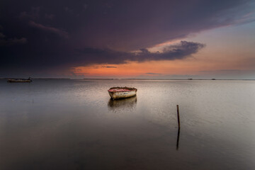 barco en la bahia del fangar en el dela del ebro, con un cielo nublado