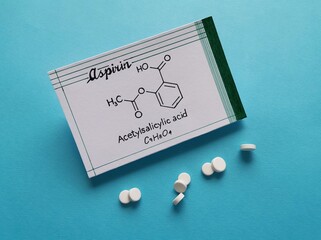 Structural chemical formula of aspirin molecule with pills and tablets in the background. Aspirin...