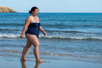 Fototapeta premium Body positive. Happy plump woman on the beach. 