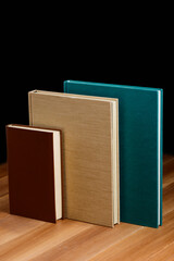 Hardcover books on the wooden table. Different size and color of cover