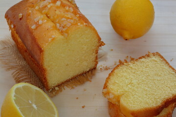 slices of lemon cake with lemon on wooden table close up