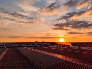 Cloudy sunset over factory roof