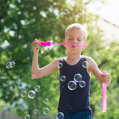 blond hair boy blowing soap bubbles