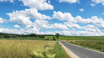 Impressive sky with cumulus clouds over a rural landscape with an asphalt road.
Germany, Hesse near Kirtorf
