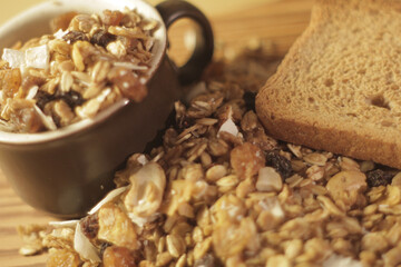 a cup with cereal and nuts on a rustic wooden table with a healthy toast