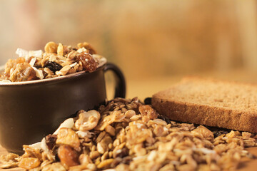 a cup with cereal and nuts on a rustic wooden table with a healthy toast