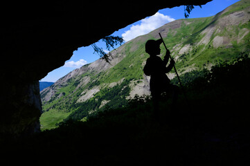 boy in a cave in the mountains