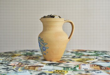 jug with coins on a table with money. concept on the topic of finance