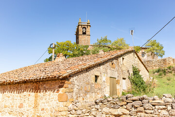 an antique rustic house and the tower of the Parish church of the Nativity of Our Lady in Revilla...