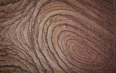 brown stone background with a pattern of concentric lines lines