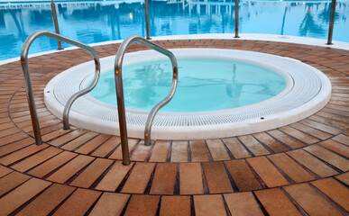 Detail of swimming pool with stainless handrails at tropical resort. Summer vacation or travel concept.