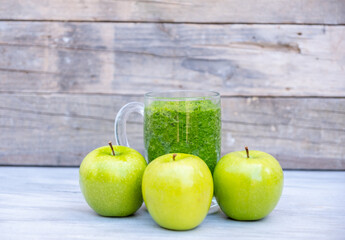 Healthy smoothie with three apples around it