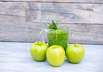 Healthy smoothie with three apples around it